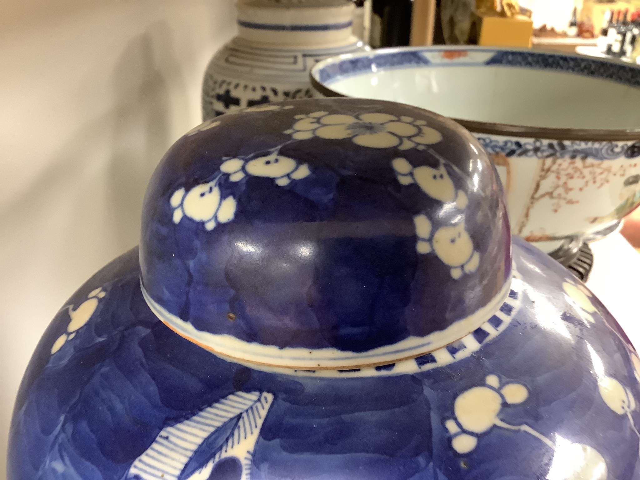 A 19th century Chinese porcelain prunus jar and cover, 27cm, on carved wood stand, a smaller famille noire jar and cover, a Chinese export fruit bowl, blue and white dish and a similar jar and cover 27cm
